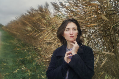 Portrait of beautiful young woman standing on land