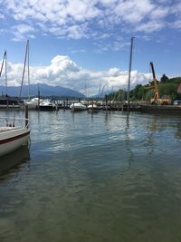 Sailboats moored in sea against sky