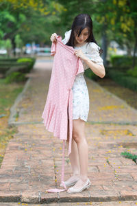 Full length of woman standing on footpath