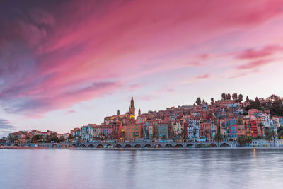 River with buildings in background at sunset