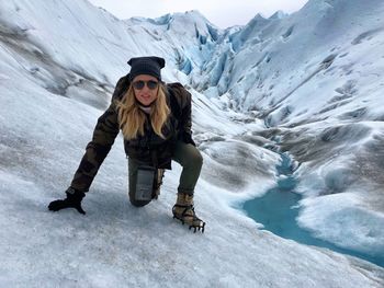 Portrait of woman crouching on glacier 