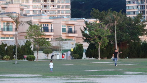 People playing soccer on street by buildings