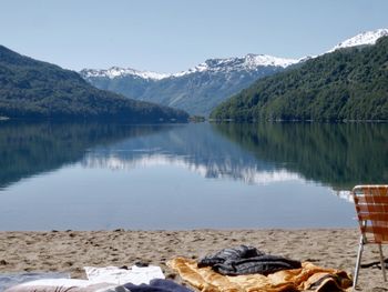 Scenic view of lake by mountains against sky