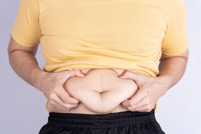 Midsection of woman standing against white background