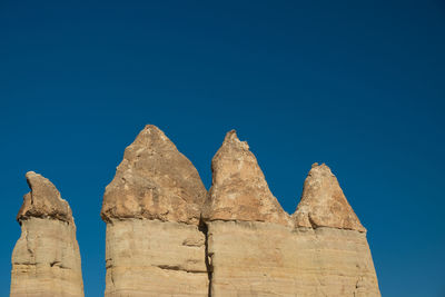 Low angle view of old ruins against clear blue sky