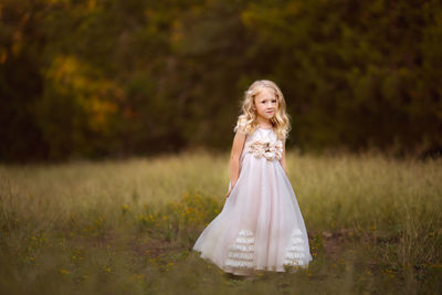 Portrait of young woman standing on field