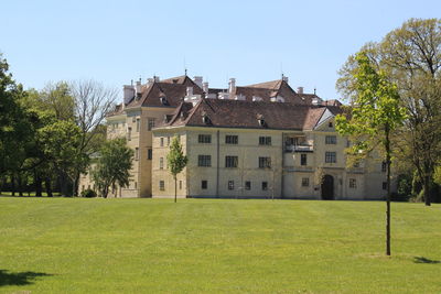 Buildings against clear sky with lawn in foreground