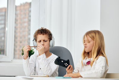 Young woman using mobile phone while sitting at home