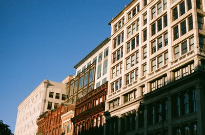 Low angle view of buildings against clear blue sky