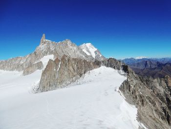 Scenic view of snowcapped mountains against clear blue sky