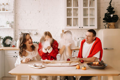 Family with children having fun and laughing while preparing for the christmas holiday in kitchen