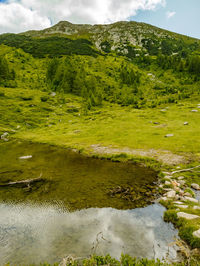 Scenic view of lake by mountain against sky