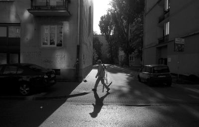 Person on street amidst buildings in city