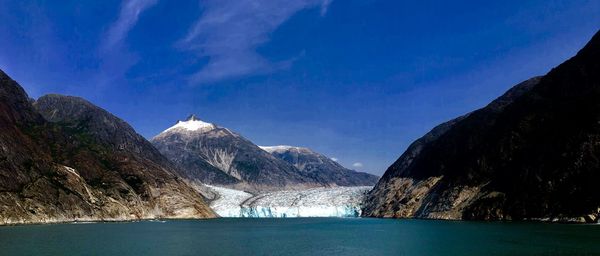 Panoramic view of lake and mountains against blue sky