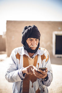 Senior man using cell phone in smara refugee camp, tindouf, algeria
