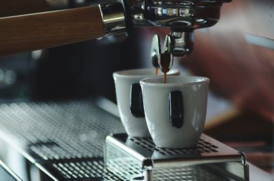 Close-up of coffee cups on espresso maker