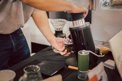 Barista grinding coffee beans in coffee shop