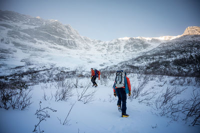 People on snowcapped mountain against sky