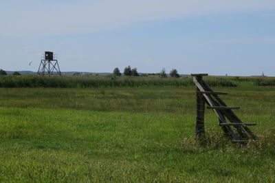 Metallic structure on field against sky