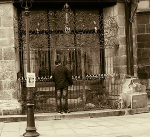 Rear view of woman standing against built structure