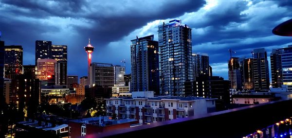 Modern buildings in city against sky at dusk