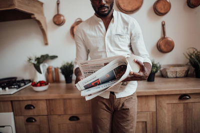 Midsection of man standing on table at home