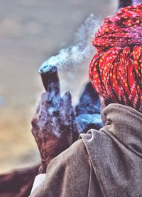 Rear view of man smoking outdoors