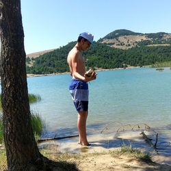 Strong teenager lifting stone with his hand