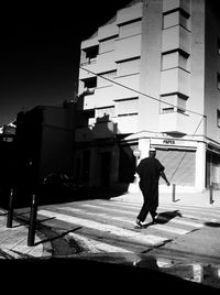 Full length rear view of man walking on street in city