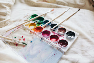 High angle view of paint palette and brushes