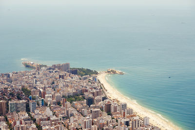 High angle view of townscape by sea against sky