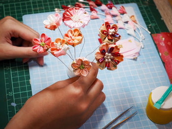 Cropped hands holding artificial flowers