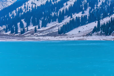 Scenic view of mountains against blue sky during winter