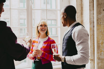 Smiling businesswoman enjoying drinks with male colleague during event at convention center