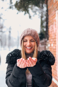 Portrait of smiling young woman in snow