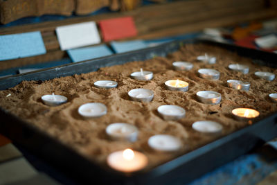 Defocused background with burning votive candles in the church. close up.