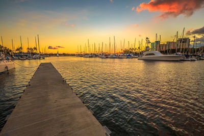 Sailboats in sea at sunset