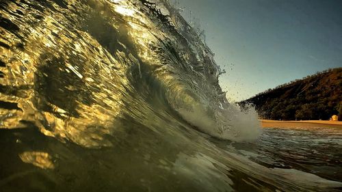 Sea waves splashing against clear sky