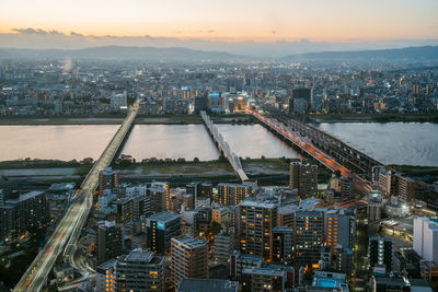 High angle view of illuminated cityscape against sky at night