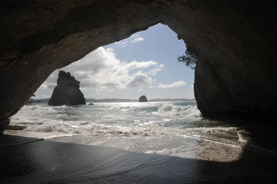 Sea seen through cave on sunny day