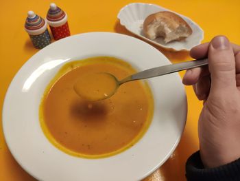 High angle view of man eating pumpkin soup