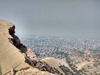 Aerial view of sea and cityscape against sky