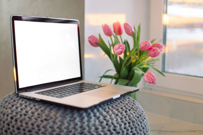 Close-up of white roses in vase on table at home