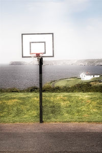 Basketball hoop on field against sky