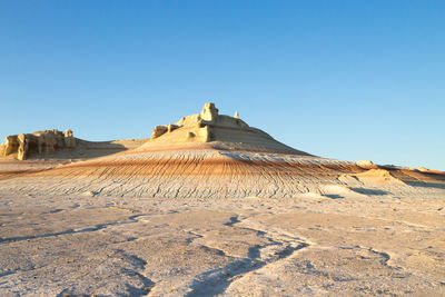 Scenic view of desert against clear blue sky