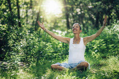 Full length of woman sitting on land