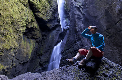 Full length of woman sitting on rock