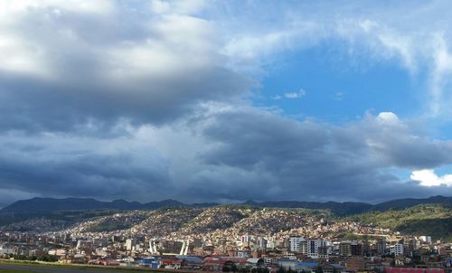 Aerial view of city against cloudy sky