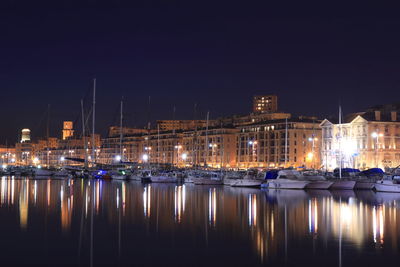 Sailboats moored in river at night