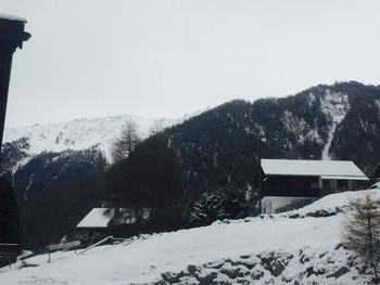 House by trees against clear sky during winter